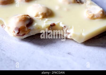 White chocolate with hazelnuts on a gray table close up Stock Photo