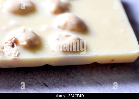 White chocolate with hazelnuts on a gray table close up Stock Photo