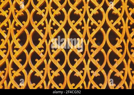 Close-up of an ornate forged gold-covered grid of air duct in arabic style vent. Oriental flower pattern of vent grille. Stock Photo