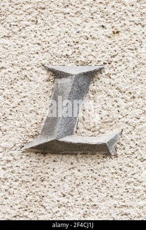 Capital letter L on roughly plastered wall Stock Photo