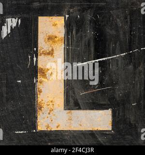 Weathered golden letter L on black background Stock Photo