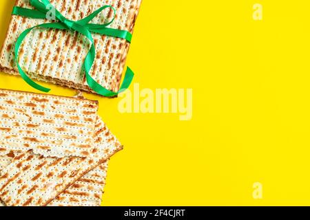 Traditional Jewish matzo on yellow background. Happy Passover. Pesach religious holiday celebration concept. Matzah bread. Copy space. Stock Photo