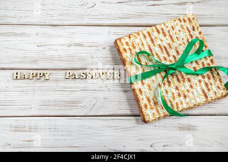 Happy Passover. Matzah on white wooden background. Traditional Jewish regilious holiday of Pesach. Matzo bread. Stock Photo