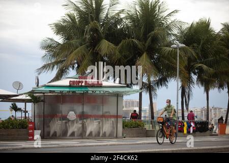 06 March 2021, Brazil, Rio De Janeiro: A man rides his bike past a closed kiosk on Brazil's Copacabana beach.(File photo) Photo: Fernando Souza/dpa Stock Photo