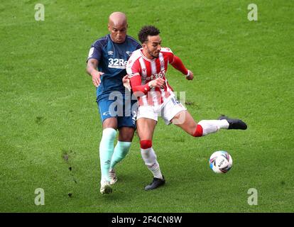 Derby County's Andre Wisdom (left) battle for the ball with Stoke City's Jacob Brown during the Sky Bet Championship match at the bet365 Stadium, Stoke-on-Trent. Picture date: Saturday March 20, 2021. Stock Photo