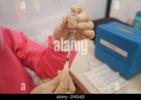 A health worker prepares a dose of Covid-19 vaccine at Kendari City ParkThe mass vaccination program for the elderly was officially implemented on Saturday (20/3/2021) at Kendari City Park. As previously planned by the Kendari City Government, vaccination for the elderly is a priority because the majority of deaths among people with Covid-19 in Kendari City are elderly. The mass vaccination itself will be carried out for one week from March 20 to 27 starting at 8 to 12 o'clock local time. The requirements if you want to get a vaccine injection are also very easy, namely only by bringing a Kend Stock Photo