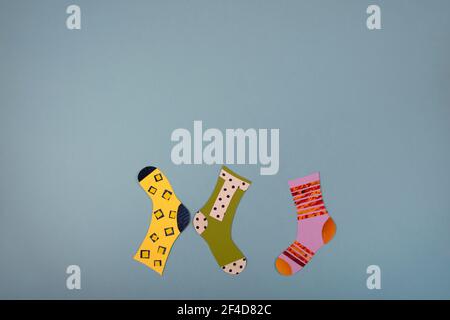 World Down Syndrome Day concept. Different socks made from paper on blue background. Flat lay, top view. Copy space. Stock Photo