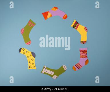 World Down Syndrome Day concept. Different socks made from paper on blue background. Flat lay, top view. Copy space. Stock Photo
