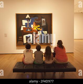 Listening to the concert: Pablo Picasso, Three Musicians at the Museum of Modern Art, MoMA,  in New York City. Stock Photo