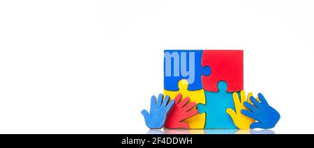 Colorfull puzzles hands on white background. World Autism Awareness Day Concept Stock Photo