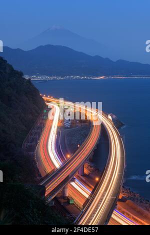 Lakeshore road with light trails and Mt Fuji in the distance, Yamanashi, Honshu, Japan Stock Photo