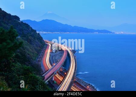 Lakeshore road with light trails and Mt Fuji in the distance, Yamanashi, Honshu, Japan Stock Photo
