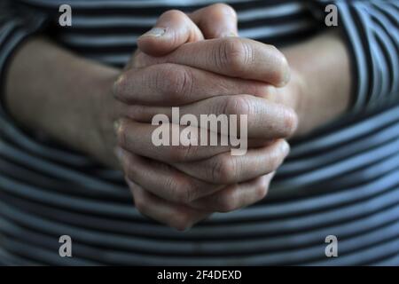 woman praying hands together on grey background stock photo Stock Photo