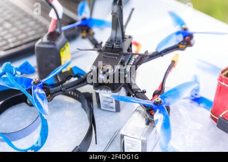 A fpv high-speed racing drone copter and tools lying on the table Stock Photo