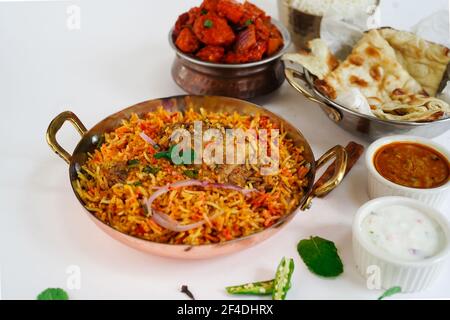Indian Non veg meal Chicken biryani Roti Chilli chicken rice salan and Raita isolated on white Stock Photo