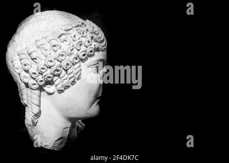 Black and white photo of profile of ancient female roman head sculpted in marble and in ruins Stock Photo