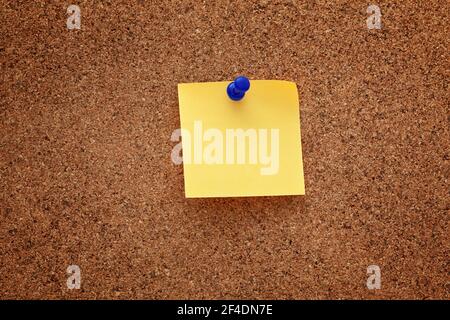 A blank paper note pinned on a cork board. Close up. Stock Photo