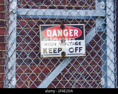 Danger high voltage sign on fence Stock Photo