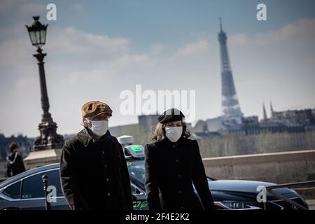 Paris, France. 20th Mar, 2021. People with face masks walk on a street in Paris, France, on March 20, 2021. French Prime Minister Jean Castex on Thursday announced 'new massive measures' to curb COVID-19 in the country's 16 worst-hit regions, including Paris. Starting Friday midnight, about 18 million French people in regions such as Paris, Hauts-de-France in the north as well as the Alpes-Maritimes on the Mediterranean should stay at home, Castex announced at a press briefing on the epidemic situation. Credit: Aurelien Morissard/Xinhua/Alamy Live News Stock Photo