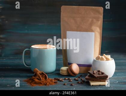 cup of coffee, coffee beans, sugar, craft paper, macaroons and chocolate on wooden background Stock Photo