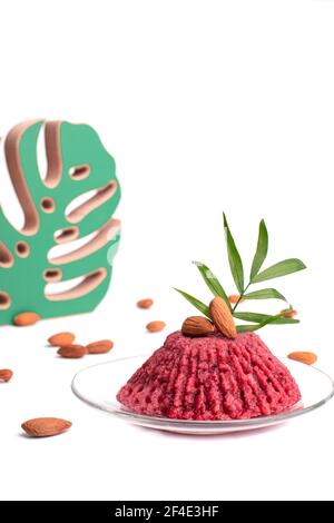 Aquafaba ice cream. Healthy sweets. Proper nutrition. A cake with fruit on top of a table.Monstera leaf decor on background Stock Photo