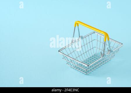 metal wire shopping basket isolated on blue background Stock Photo