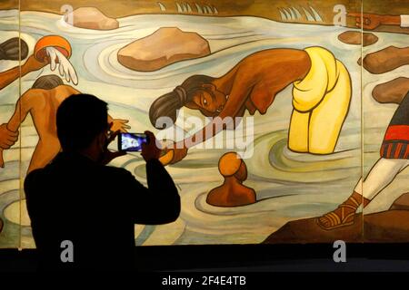 MEXICO CITY, MEXICO - MARCH 16: A person takes a photo to a paint during a tour inside at Munal Museum, amid orange alert of Covid-19, while  it has been allowed resumption museums. The National Art Museum applies sanitary measures in its reopening to the public by presenting the permanent exhibitions: The 20th Century in the 21st, Mural Collection; works by muralists Dr. Atl, Maria Izquierdo, Rufino Tamayo, JosÈ Clemente Orozco, Diego Rivero and David Alfaro Siqueiros, among many others. On March 16, 2021 in Mexico City, Mexico. Credit: Luis Barron/Eyepix Group/The Photo Access Stock Photo