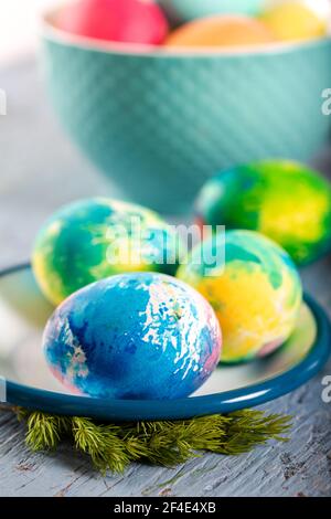Colorful easter eggs on a blue wooden table. Selective focus.