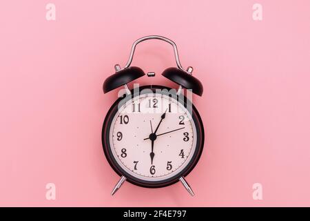 Black alarm clock on pink background Stock Photo