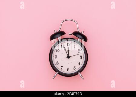 Black alarm clock on pink background Stock Photo