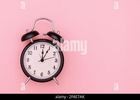 Black alarm clock on pink background Stock Photo