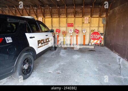 A 2018 Ford Explorer Police Interceptor SUV sits with a row of traffic control signs under a carport at Purdue University Fort Wayne. Stock Photo