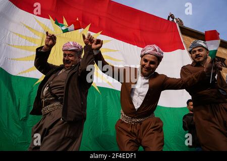 Iraqi Kurds dancing next to the Kurdistan flag during the Nowruz ...