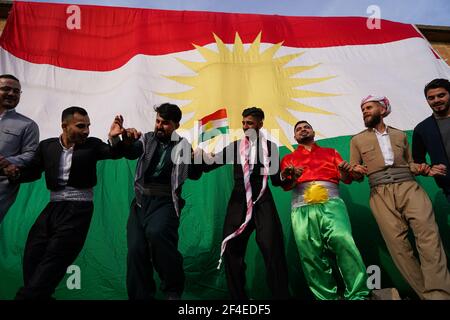 Iraqi Kurds dancing next to the Kurdistan flag during the Nowruz ...
