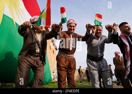 Iraqi Kurds dancing next to the Kurdistan flag during the Nowruz ...