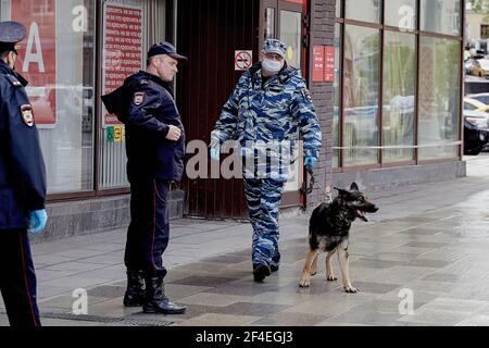 Moscow, Russia. 23rd May, 2020. A cynologist with a dog patrols the bank premises. The hostage situation at an Alfa-Bank branch located on Zemlyanov Val Street in central Moscow has been resolved after police stormed the building and arrested the perpetrator on Saturday, May 23. Police sources said that the man released the hostages before the police stormed the building. The area surrounding the bank remains cordoned off, and residual traffic disruption is to be expected in the area over the coming hours. (Photo by Mihail Tokmakov/SOPA Images/Sipa USA) Credit: Sipa USA/Alamy Live News Stock Photo