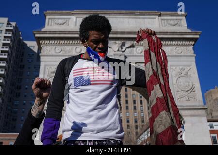 New York City, USA. 20th Mar, 2021. A man raises his fist holding an American flag in Washington Square Park in New York City, USA during a vigil in remembrance of the eight people, including six Asian women, killed at three spas in Atlanta, Georgia on March 16, 2021. Credit: Chase Sutton/17�Թ����� Live News Stock Photo