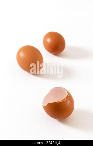 Fresh chicken whole eggs and a broken egg isolated on white background. Stock Photo