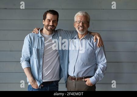 Portrait of happy old father and adult son hugging Stock Photo