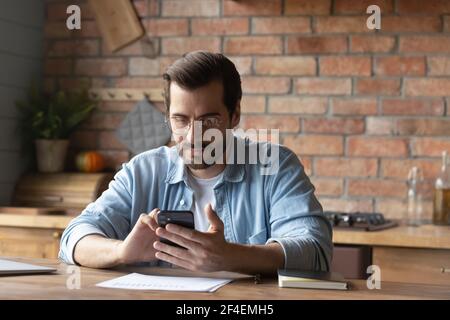Young Caucasian man use smartphone texting online Stock Photo