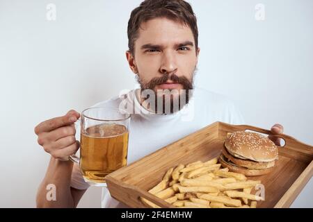 Man with a mug of beer fast food diet food alcohol fun light background Stock Photo