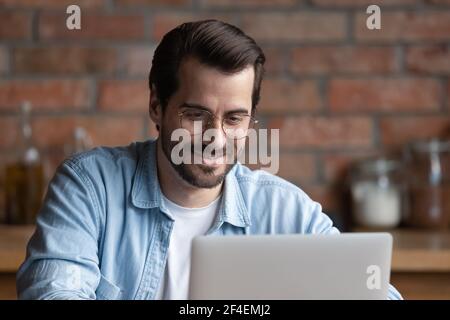 Young man work on laptop gadget from home Stock Photo