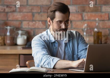 Caucasian male employee work on laptop from home office Stock Photo