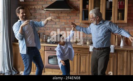 Happy three generations of men dancing at home Stock Photo