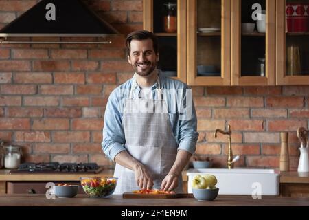 Portrait of smiling man cooking in home kitchen Stock Photo