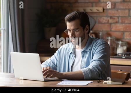 Young Caucasian man work online on laptop Stock Photo