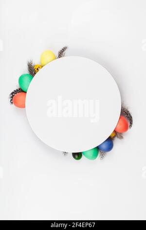 layout made with colorful Easter eggs with feathers. Minimal Easter background. Spring holidays concept. copy space flat lay top view paper card. Stock Photo