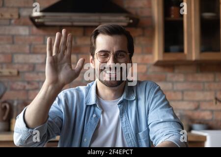 Smiling young man wave talking on video call Stock Photo