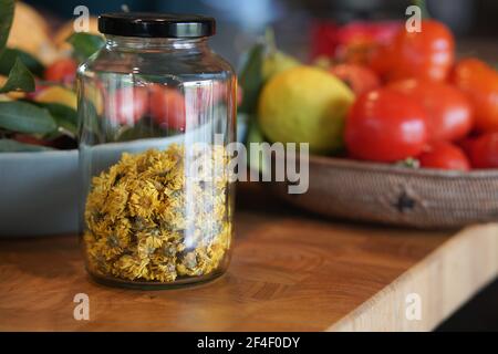 dried chrysanthemum flower in glass jar in kitchen. herbal herb tea Stock Photo