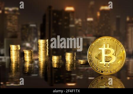 Bitcoin and stack coins of baht on the night city background.  Finance and investment concept. Stock Photo